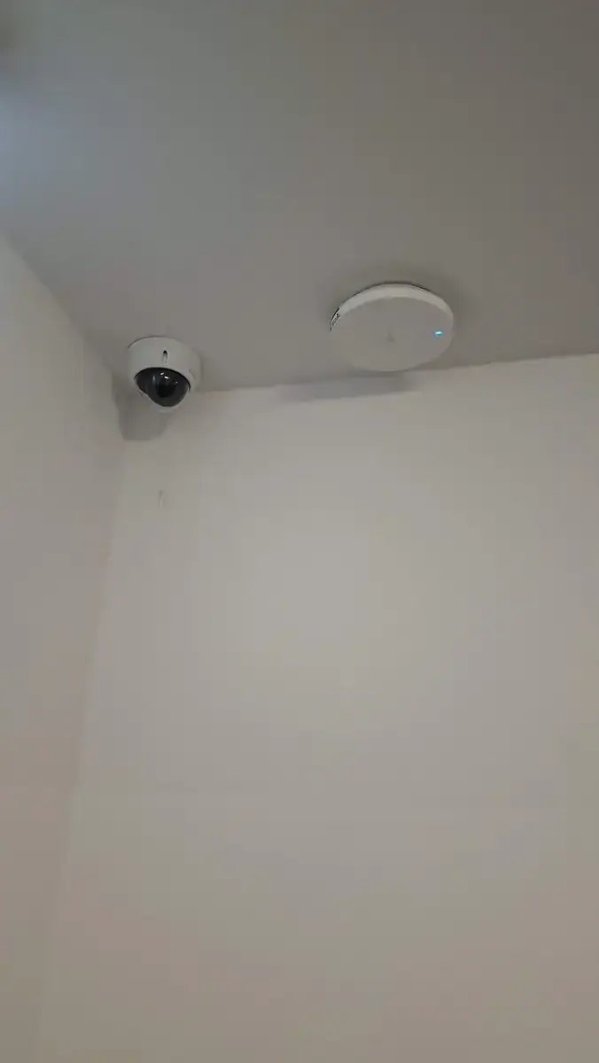 Dome-Kamera und WLAN Access Point an der Decke eines Innenraums
